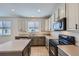 Kitchen featuring tiled floors, granite countertops, and modern black appliances at 1436 Turnberry Dr, Castle Rock, CO 80104
