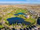 Picturesque aerial view of Reunion community park featuring ponds, green spaces, and a recreational barn in the distance at 17035 E 102Nd Pl, Commerce City, CO 80022