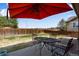 Backyard featuring a patio with a black table and chairs, a fenced-in yard, and some grass at 17035 E 102Nd Pl, Commerce City, CO 80022