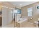 Relaxing bathroom featuring a walk-in shower and a soaking tub, perfect for unwinding after a long day at 17035 E 102Nd Pl, Commerce City, CO 80022