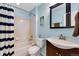 Bathroom with blue walls, a dark vanity, a bathtub with shower and striped shower curtain at 17035 E 102Nd Pl, Commerce City, CO 80022