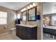 Well-lit primary bath with dual sinks, stylish vanity, and updated fixtures, steps away from main bedroom at 17035 E 102Nd Pl, Commerce City, CO 80022