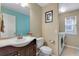 Half bath with a dark vanity, toilet, mirror, and nearby laundry machines at 17035 E 102Nd Pl, Commerce City, CO 80022
