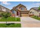 Charming two-story home featuring a well-maintained lawn, brick accents, and a two-car garage at 17035 E 102Nd Pl, Commerce City, CO 80022