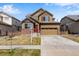 Two-story home featuring a well-kept lawn, attached two car garage and traditional architecture at 17035 E 102Nd Pl, Commerce City, CO 80022