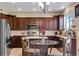 Bright kitchen featuring stainless steel appliances, dark wood cabinets, and a glass dining table at 17035 E 102Nd Pl, Commerce City, CO 80022