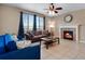 Inviting living room with a fireplace, ceiling fan and two couches with large windows at 17035 E 102Nd Pl, Commerce City, CO 80022