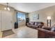 Cozy living room featuring a leather sofa, tile flooring, and a bright window at 17035 E 102Nd Pl, Commerce City, CO 80022