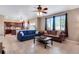 Open concept living room featuring tile flooring, a ceiling fan, and ample natural light from large windows at 17035 E 102Nd Pl, Commerce City, CO 80022
