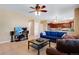 Bright living room showcasing tile floors, ceiling fan and open access to the adjacent kitchen space at 17035 E 102Nd Pl, Commerce City, CO 80022
