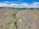 Expansive aerial view of a mountain landscape with scattered homes and winding roads under a blue sky at 718 Emerson Gulch Rd, Boulder, CO 80302