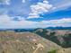 Stunning aerial shot capturing the vast mountain terrain featuring homes surrounded by lush greenery and clear skies at 718 Emerson Gulch Rd, Boulder, CO 80302