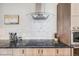Close-up of a kitchen showcasing stone countertops, modern appliances, a mosaic backsplash, and light wood cabinets at 718 Emerson Gulch Rd, Boulder, CO 80302