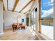 Bright living room features exposed wood beams, hardwood floors, and a sliding glass door with mountain views at 718 Emerson Gulch Rd, Boulder, CO 80302