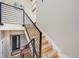 Staircase with wood steps and black metal railings that lead to the lower level and the main entry door at 718 Emerson Gulch Rd, Boulder, CO 80302