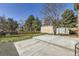 A spacious backyard featuring a concrete patio, gravel bed, lawn, and mature trees at 4160 E 115Th Pl, Thornton, CO 80233