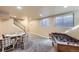 Expansive finished basement with neutral carpet, game area, and staircase at 4160 E 115Th Pl, Thornton, CO 80233