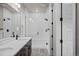 Bright bathroom featuring a double sink vanity and tiled shower with glass doors at 16605 Peak St, Broomfield, CO 80023