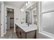 Bathroom featuring a double sink vanity, quartz countertop, and a frosted window at 16605 Peak St, Broomfield, CO 80023