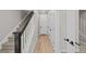Bright hallway with hardwood floors and a staircase with designer dark wood and white railings at 16605 Peak St, Broomfield, CO 80023