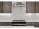 This kitchen features a modern stainless steel range hood over a gas range and a white backsplash at 16605 Peak St, Broomfield, CO 80023