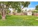 A spacious backyard with a lush green lawn, a wooden fence, mature trees, and a storage shed providing a private outdoor space at 2970 Leyden St, Denver, CO 80207