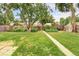 Spacious backyard with a grassy area, mature trees, and a wooden fence at 2970 Leyden St, Denver, CO 80207