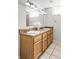 Bathroom with a double sink vanity, ample storage, decorative countertop, large mirror and modern lighting at 2970 Leyden St, Denver, CO 80207