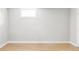 Empty bedroom features hardwood floors, white walls, and a small window for natural light at 2970 Leyden St, Denver, CO 80207