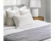 Close up of the bed featuring throw pillows and a nightstand with a lamp at 2970 Leyden St, Denver, CO 80207