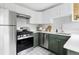 Modern kitchen featuring stainless steel appliances, green lower cabinets, and patterned tile flooring at 2970 Leyden St, Denver, CO 80207
