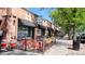 Scoops Ice Cream shop with a brick facade, black awnings, and colorful outdoor seating along a sidewalk at 2970 Leyden St, Denver, CO 80207