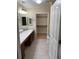Well-lit bathroom with double sink vanity, tiled floors, and access to a walk-in closet at 15346 Heritage Cir, Thornton, CO 80602