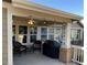 Inviting covered patio features string lights, comfortable seating, and outdoor grill at 15346 Heritage Cir, Thornton, CO 80602