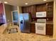 Bright kitchen features granite countertops, stainless steel refrigerator and white gas range at 15346 Heritage Cir, Thornton, CO 80602