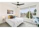 Bright bedroom featuring a large window, ceiling fan, and stylish striped bedding at 5379 W 14Th Ave, Lakewood, CO 80214