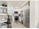 Modern kitchen featuring white cabinets, stainless steel appliances, and a dining area adjacent to the stairs at 5379 W 14Th Ave, Lakewood, CO 80214