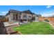 Backyard with a grassy area, patio with seating, playhouse, and an open view at 3522 N Buchanan Way, Aurora, CO 80019