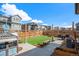 Backyard with a small playhouse, grassy area, wood fence, and patio seating area at 3522 N Buchanan Way, Aurora, CO 80019