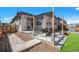 Back patio with seating, leading to a grassy yard and modern home exterior with a blue sky at 3522 N Buchanan Way, Aurora, CO 80019