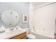 Bright bathroom with a white vanity, framed mirror, and shower over tub with white tile surround at 3522 N Buchanan Way, Aurora, CO 80019