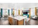 Open kitchen flows to the living area with a large island and modern finishes at 3522 N Buchanan Way, Aurora, CO 80019