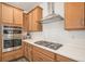 Close-up of cooktop, stainless hood and double oven in updated kitchen at 3522 N Buchanan Way, Aurora, CO 80019