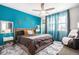 Comfortable main bedroom with a bright turquoise accent wall and ample natural light at 3522 N Buchanan Way, Aurora, CO 80019