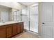 Bathroom with double sinks, modern cabinets, tiled flooring, and a large shower with glass doors at 10771 N Montane Dr, Broomfield, CO 80021