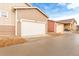 Exterior view of tan home featuring a two car garage and a driveway at 10771 N Montane Dr, Broomfield, CO 80021