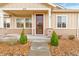 Close up of the front entrance of the ranch style home with landscaped yard and stone accents at 10771 N Montane Dr, Broomfield, CO 80021