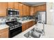 Close up of the kitchen featuring stainless steel appliances, island sink, and modern backsplash at 10771 N Montane Dr, Broomfield, CO 80021