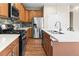 Kitchen featuring stainless steel appliances, modern backsplash, and center island with sink at 10771 N Montane Dr, Broomfield, CO 80021