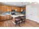 Spacious kitchen with stainless steel appliances, center island with seating, and wood floors at 10771 N Montane Dr, Broomfield, CO 80021